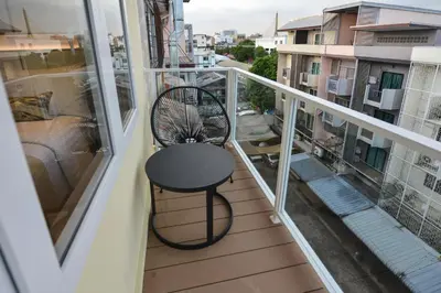 a balcony with a table and a chair at Victora Hostel in Bangkok