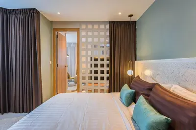 a bedroom with a large bed with blue pillows at PETRA Designer Apartment Sukhumvit, Nana BTS in Bangkok