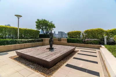 a bronze statue sitting on top of a wooden floor at Thonglor area 1 Bedroom FastWiFi Sauna Big Swimming Pool 43 in Bangkok