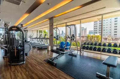 a gym with cardio equipment and a large window at Thonglor area 1 Bedroom FastWiFi Sauna Big Swimming Pool 43 in Bangkok