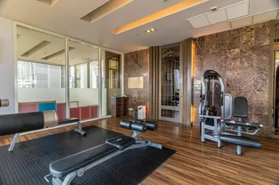 a gym with two tread machines and a mirror at Thonglor area 1 Bedroom FastWiFi Sauna Big Swimming Pool 43 in Bangkok