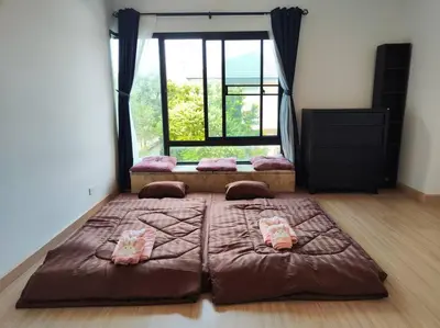 a large bed in a room with a large window at Baan Salaya in Salaya
