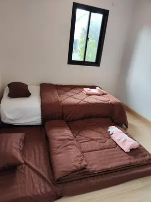 a couch with a bed in the corner of a room at Baan Salaya in Salaya