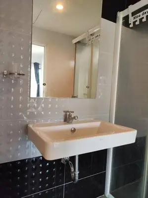 a bathroom with a sink and a mirror at Baan Salaya in Salaya