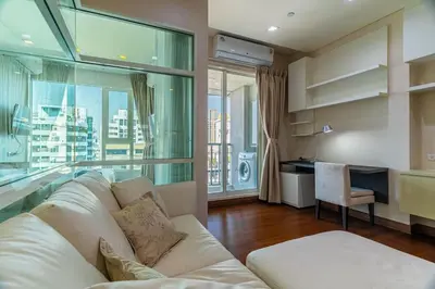 a living room with a white couch and a large window at Thonglor area 1 Bedroom FastWiFi Sauna Big Swimming Pool 38 in Bangkok