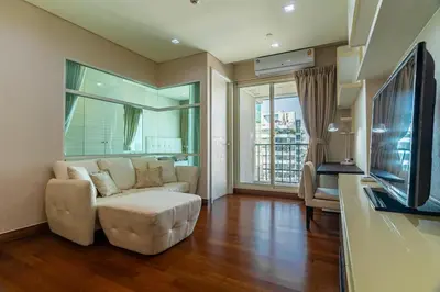 a living room with a couch and a tv at Thonglor area 1 Bedroom FastWiFi Sauna Big Swimming Pool 38 in Bangkok
