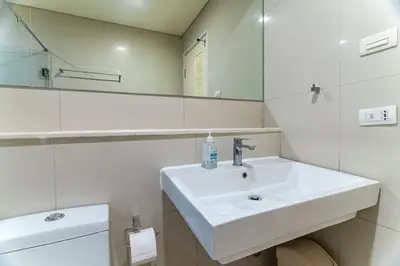 a white bathroom with a sink and a mirror at Thonglor area 1 Bedroom FastWiFi Sauna Big Swimming Pool 38 in Bangkok