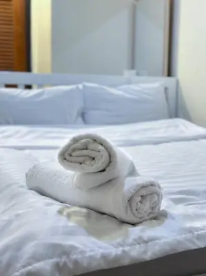 a stack of towels sitting on a bed at Chubbi5 room11 in Bangkok