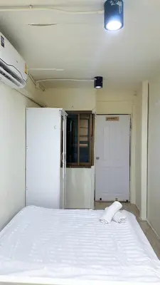 a white bed in a room with a door at Chubbi5 room11 in Bangkok
