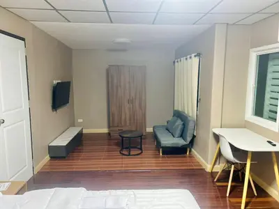 a room with a bed and a chair and a desk at 93 House in Ban Zong Katiam