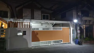 a building with a gate in front of it at night at 93 House in Ban Zong Katiam