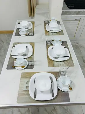 a table with white plates and glasses on it at 93 House in Ban Zong Katiam