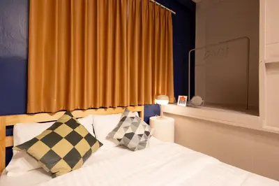 a bedroom with a bed with two pillows and a window at Siam Twin Charoenkrung in Bangkok