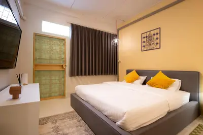 a bedroom with a large bed with yellow pillows at Siam Twin Charoenkrung in Bangkok