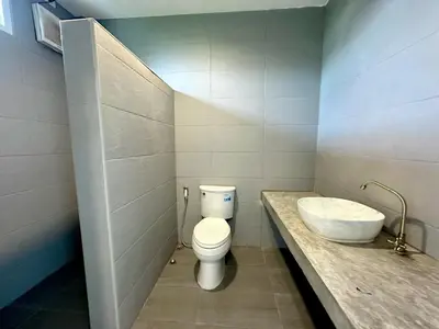 a bathroom with a white toilet and a sink at Woodview Resort in Samut Prakan
