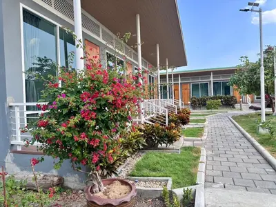 a building with a bunch of flowers in front of it at Woodview Resort in Samut Prakan