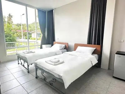 a hotel room with two beds and a window at Woodview Resort in Samut Prakan