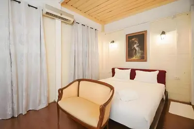 a bedroom with a white bed and a chair at XX Mitr Inn Yaowarat - China Town in Bangkok