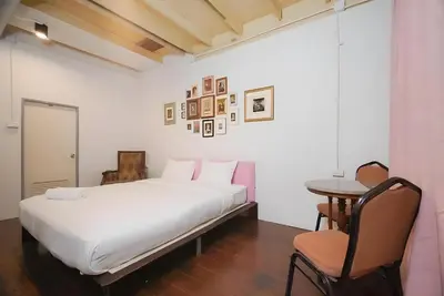 a bedroom with a bed and a table and a chair at XX Mitr Inn Yaowarat - China Town in Bangkok