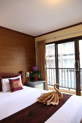 a bedroom with a large bed and a large window at Tanee Place in Bangkok