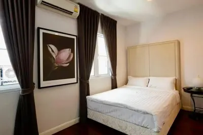 a bedroom with a bed and a pink flower on the wall at Townhome 3 bed4 Baht Asok MRTBTS Sukhumvit 16 in Bangkok