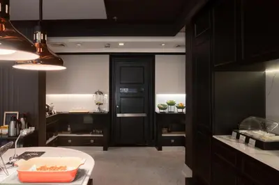 a kitchen with a black door and a sink at Skye Hotel Bangkok in Bangkok