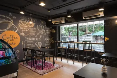 a restaurant with tables and chairs in a room at Skye Hotel Bangkok in Bangkok