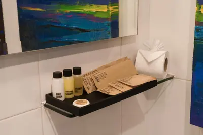 a shelf on a wall with four bottles on it at Skye Hotel Bangkok in Bangkok