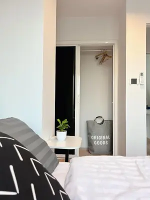 a bedroom with a bed and a table and a window at Komfy Quarters in Sathani Bang Khen