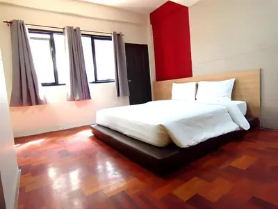 a bedroom with a large white bed and two windows at XX GO INN Silom - BTS Saint Louis สีลม in Bangkok
