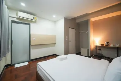 a bedroom with a white bed and a window at XX GO INN Silom - BTS Saint Louis สีลม in Bangkok