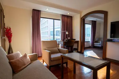 a living room with a couch and a table at Journeyhub Sukhumvit 26, Bangkok - Formerly St James Hotel in Bangkok