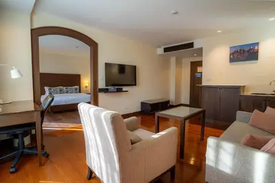 a living room with a couch and a table at Journeyhub Sukhumvit 26, Bangkok - Formerly St James Hotel in Bangkok