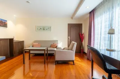 a living room with a couch and a table at Journeyhub Sukhumvit 26, Bangkok - Formerly St James Hotel in Bangkok