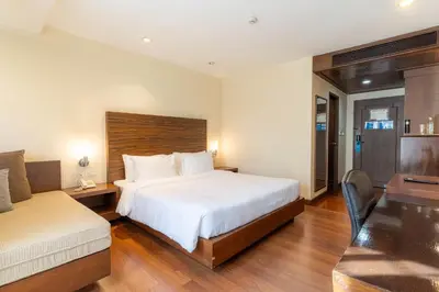 a hotel room with a large bed and a desk at Journeyhub Sukhumvit 26, Bangkok - Formerly St James Hotel in Bangkok