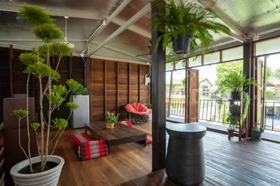 a living room with potted plants and a table at Baan Apak Wat Arun in Bangkok Noi