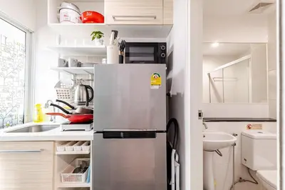 a small kitchen with a refrigerator and a sink at Perfect 1BR at MRT Bangson By Orn in Bang Su