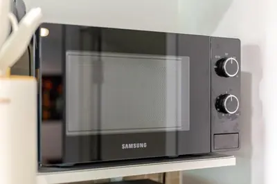 a black microwave sitting on top of a shelf at Perfect 1BR at MRT Bangson By Orn in Bang Su