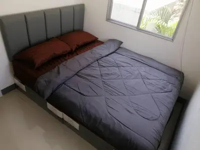 a small bed in a room with a window at Nido house in Ban Bang Phang