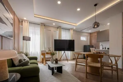 a living room with a green couch and a table at Whole Floor Penthouse, 3 Bedroom 3 Bath, Next to Metro Station in Bangkok