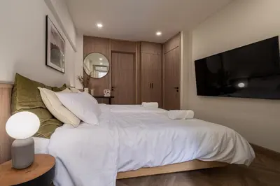 a bedroom with a large white bed and a television at Whole Floor Penthouse, 3 Bedroom 3 Bath, Next to Metro Station in Bangkok