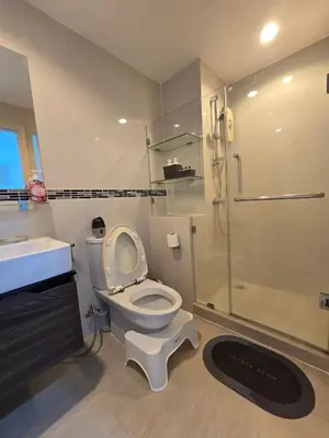 a bathroom with a toilet and a shower and a sink at Thaiphil Condo in Nonthaburi