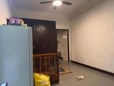 an empty room with a ceiling fan and a refrigerator at Regalohome Bkk in Bangkok