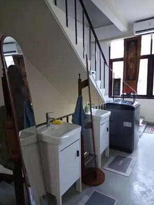 a bathroom with two sinks and a staircase at Regalohome Bkk in Bangkok