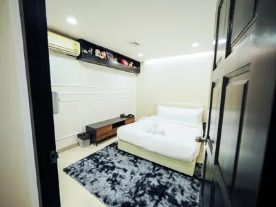 a bedroom with a white bed and a black rug at Oliver's House KS in Ban Yang