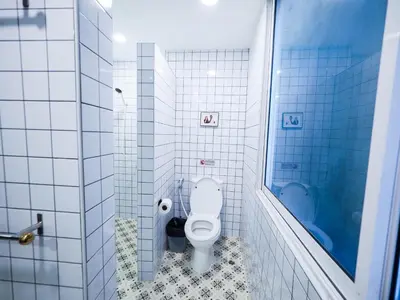 a bathroom with a toilet and a blue shower at Oliver's House KS in Ban Yang