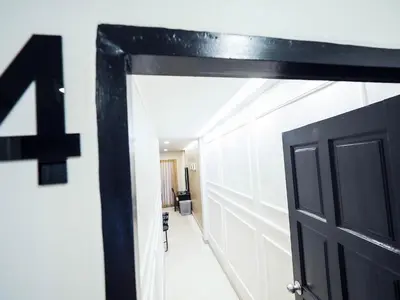 a black door with a number on the wall at Oliver's House KS in Ban Yang