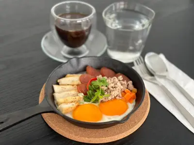 a bowl of food with eggs and vegetables on a table at Dear Sunday Hometel Bangkok in Bangkok