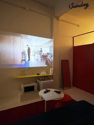 a small kitchen with a table and a microwave at Dear Sunday Hometel Bangkok in Bangkok