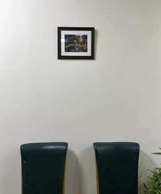 two black chairs sitting next to a wall with a picture at Atlas Hostel Khaosan in Bangkok